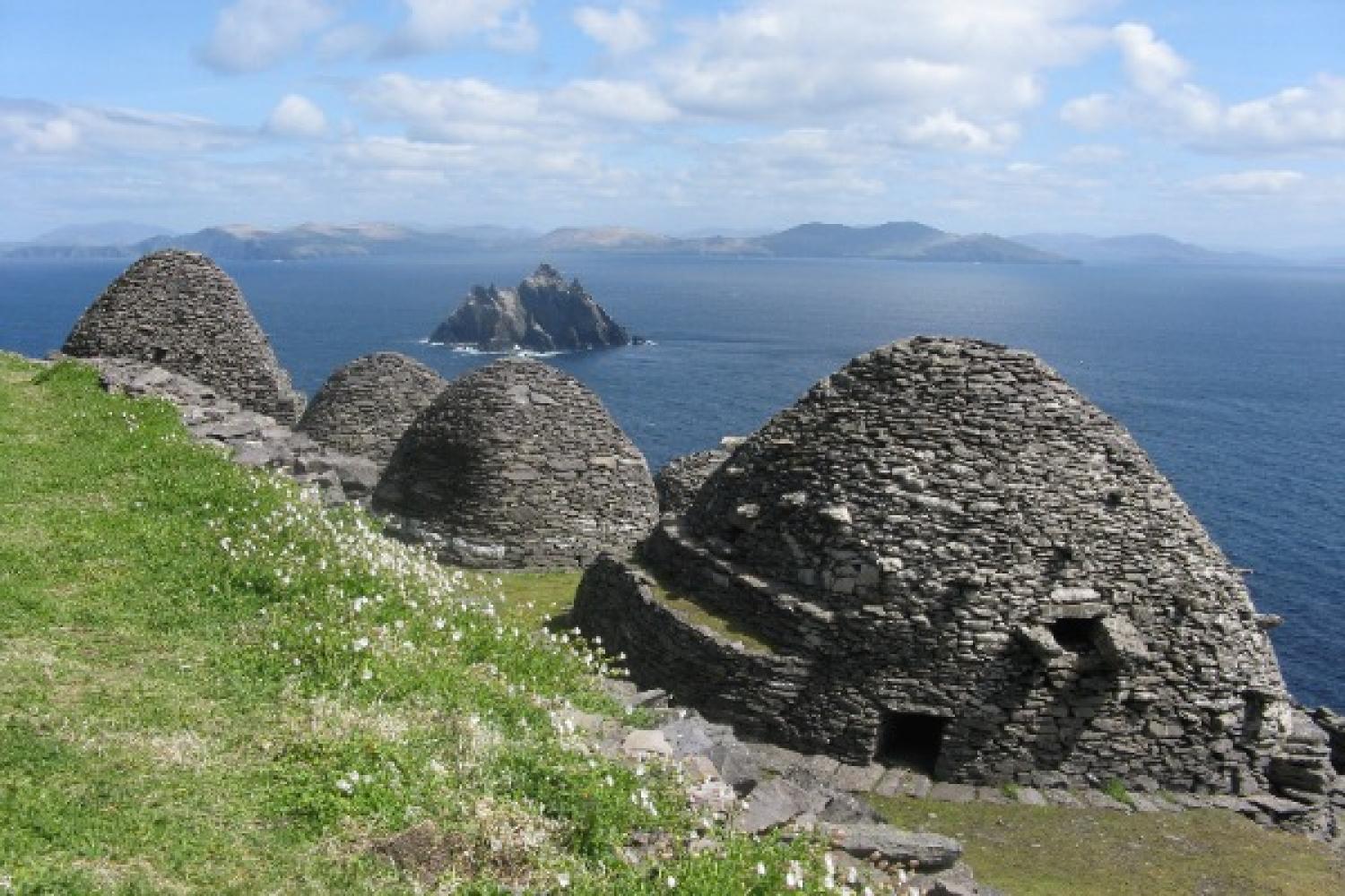 Monastic cells high above the sea on Skellig Michael, with Little Skellig and the coast of County Kerry, Ireland, in the distance.