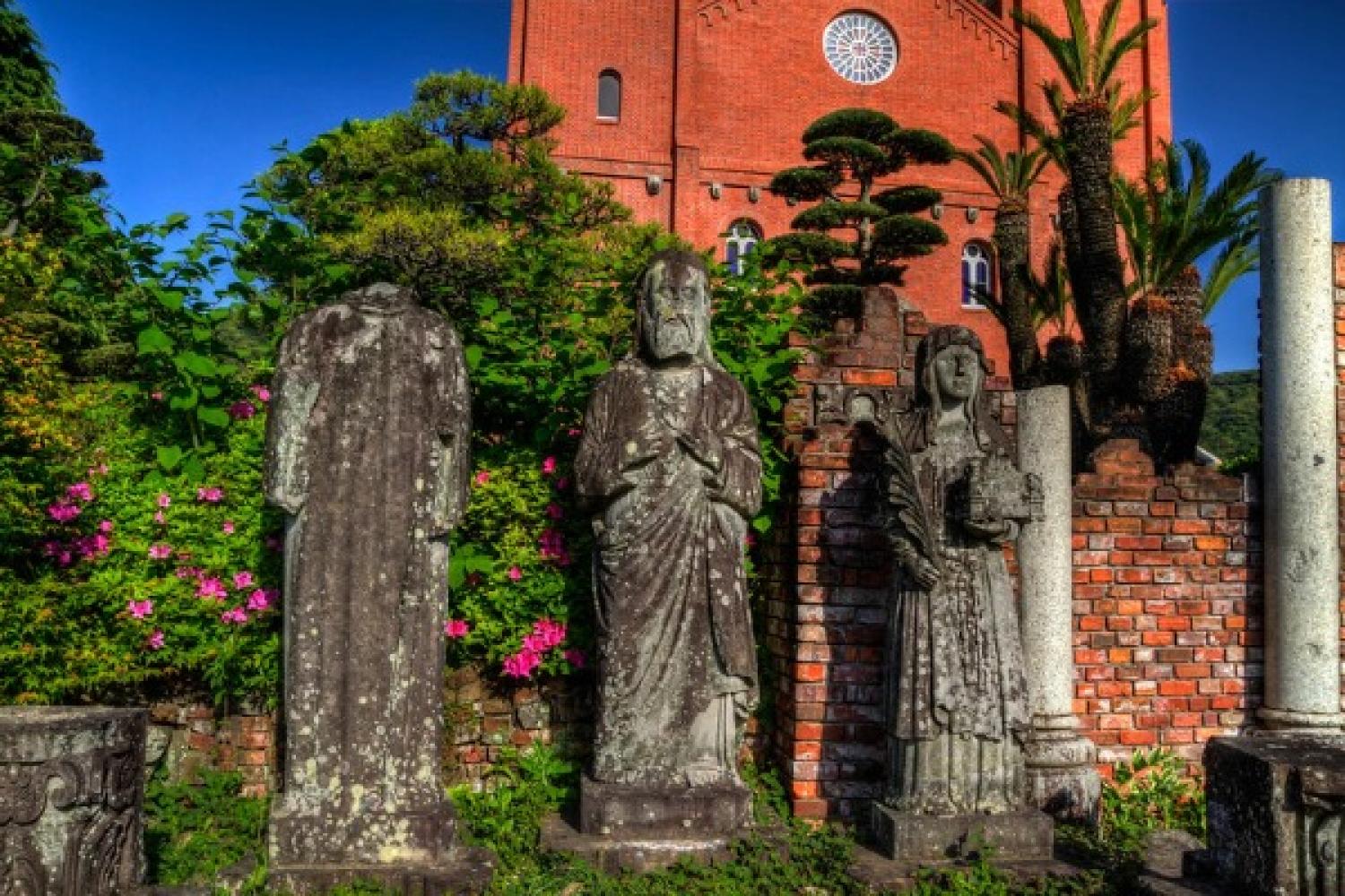 Statues and part of the brick façade from the original cathedral stand before the new church