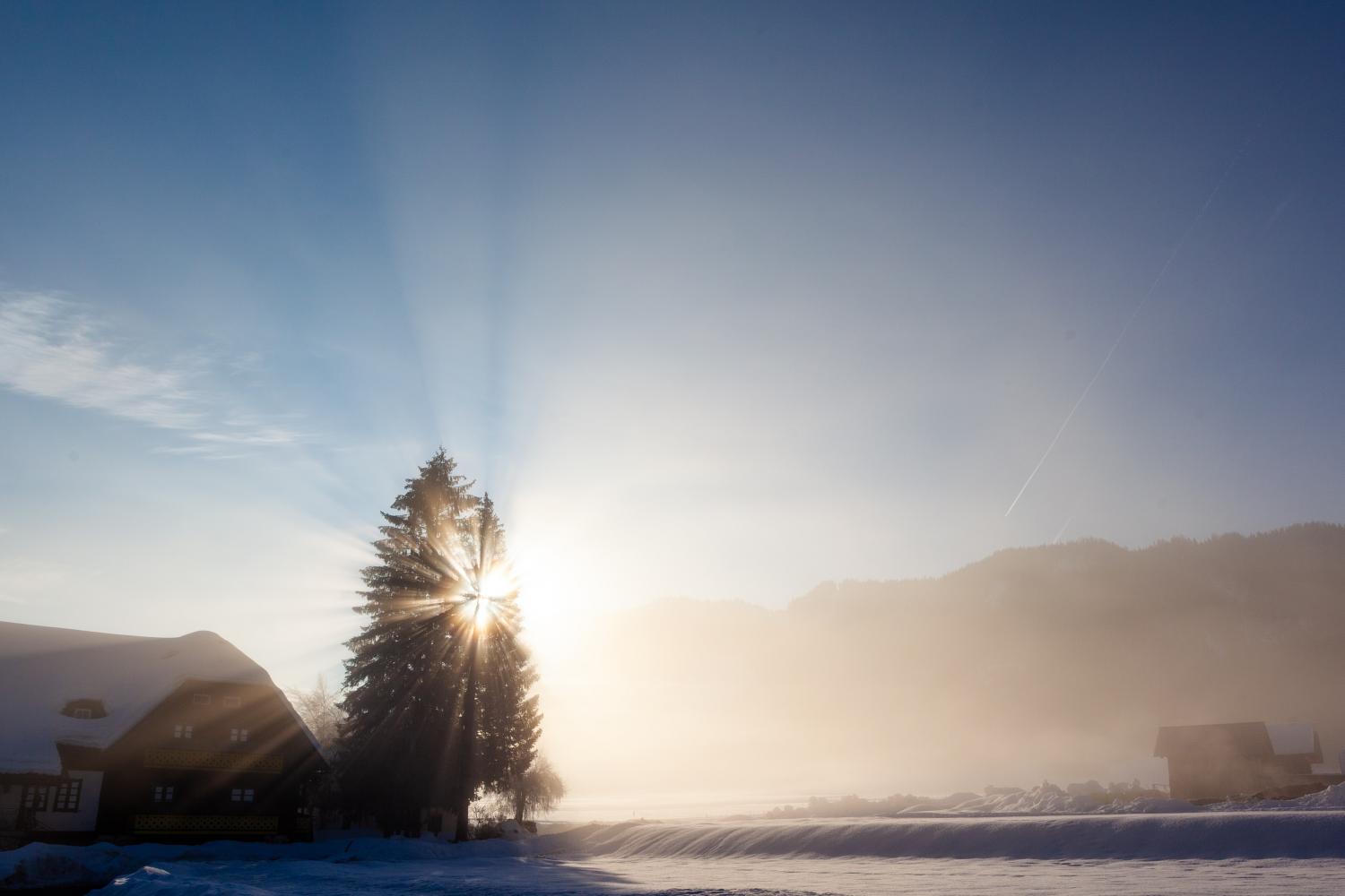 Sunrise by a barn in winter