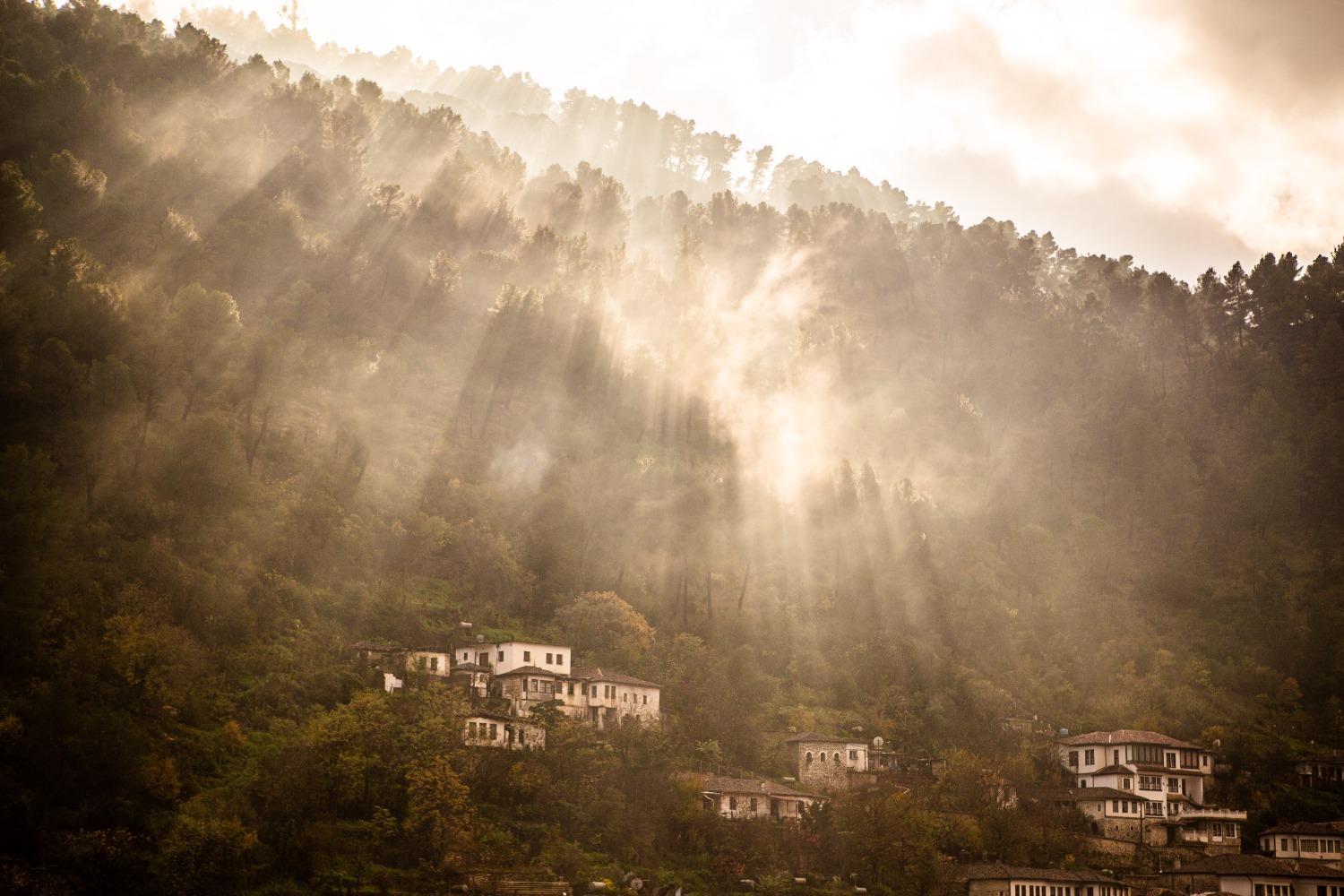 Light shines in the forested hills of Albania