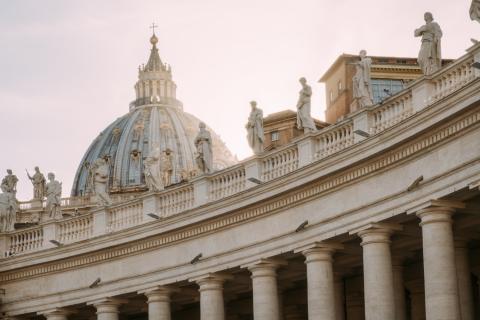 The cupola of St. Peter's Basilica rises over statues of saints on the colonnade