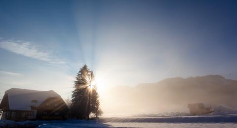 Sunrise by a barn in winter